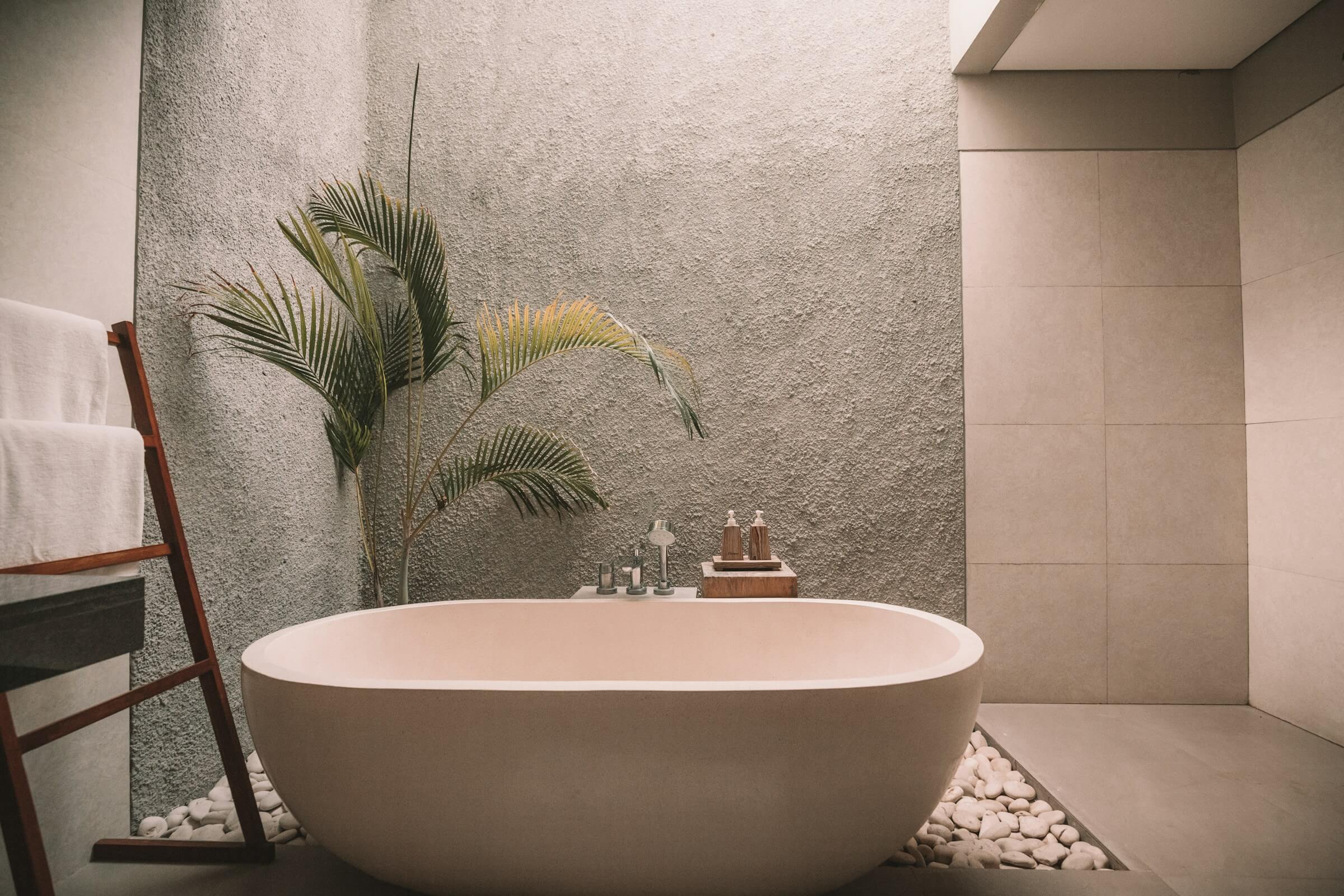Stone bathtub with natural light and plants